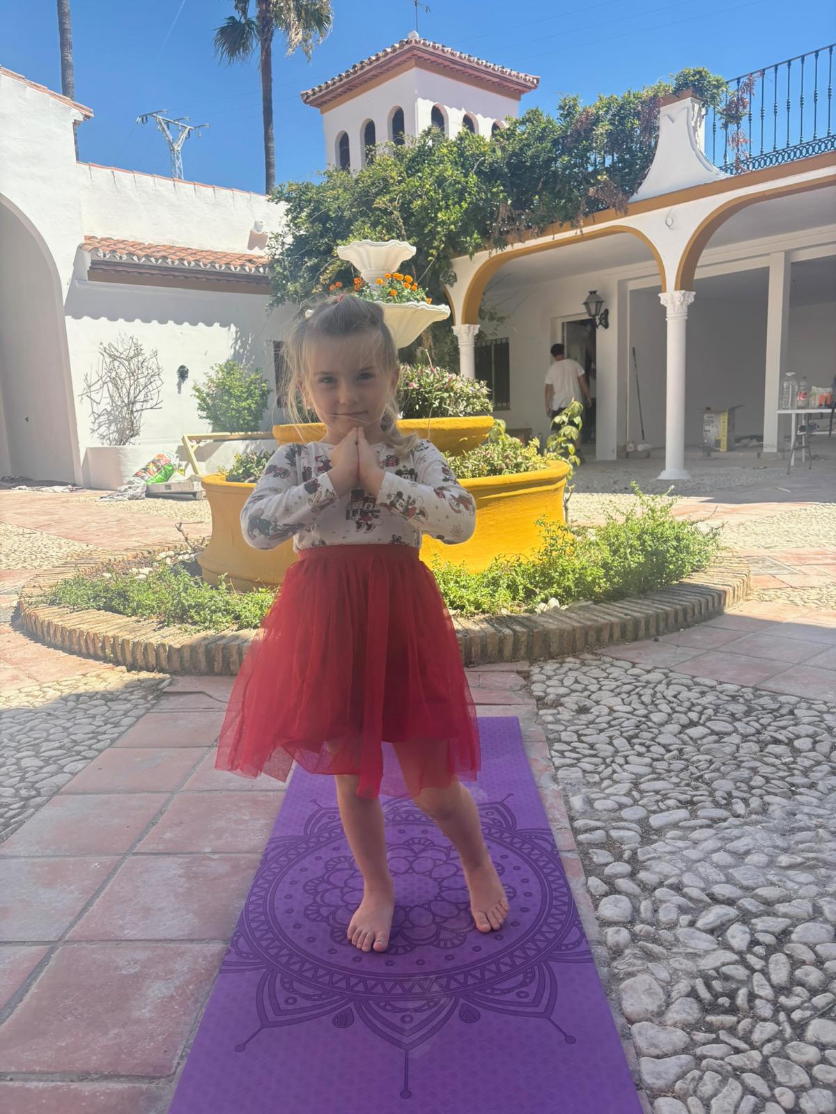 Student practising yoga at AIM School courtyard